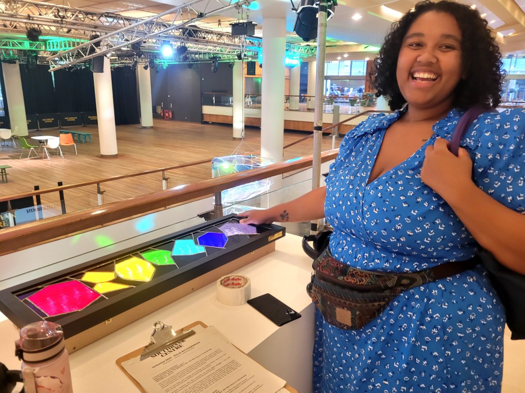 Carmen examines the coloured and textured light box alongside Portrait of a Brain sculpture.