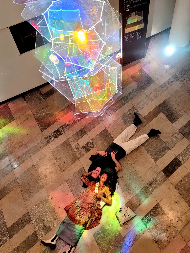 Looking down on Portrait of a Brain at Southbank Centre, a couple lie head to head underneath it. 